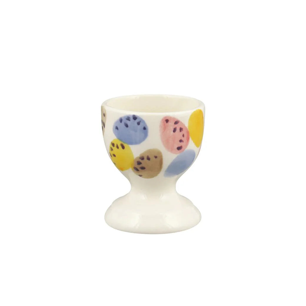 White egg cup with colorful polka dot design on a white background