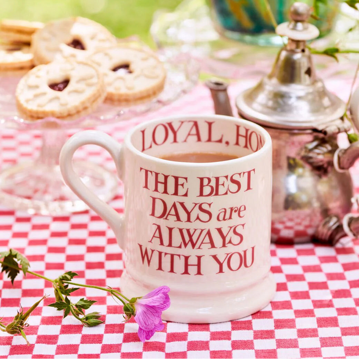 Cup of tea with a message on a checkered tablecloth outdoors