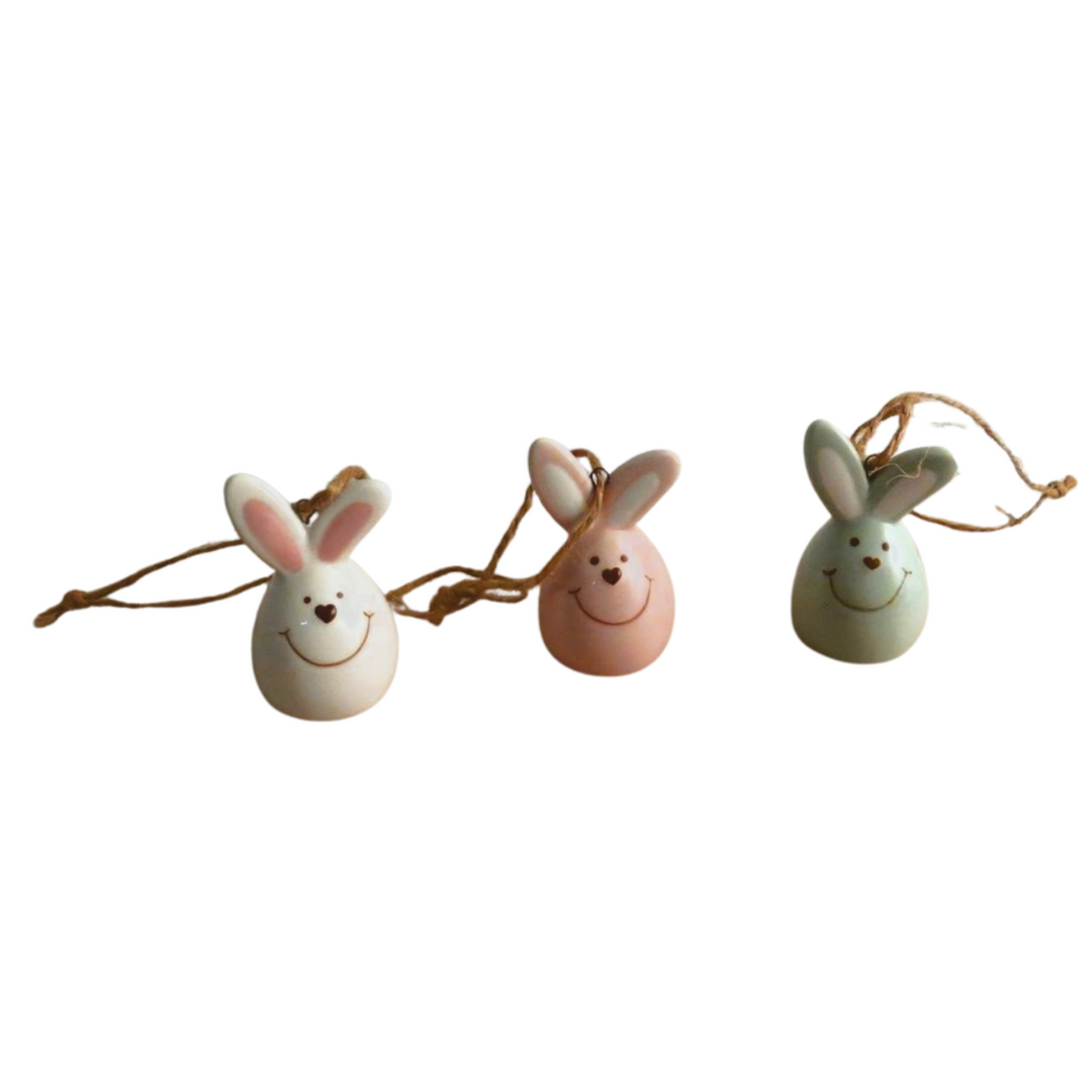 Three Easter egg-shaped bunny ornaments on a white background