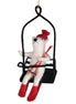 Decorative ornament of a polar bear on a ski lift with skis and a red hat.