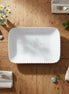 White rectangular plate with a textured rim on a white background